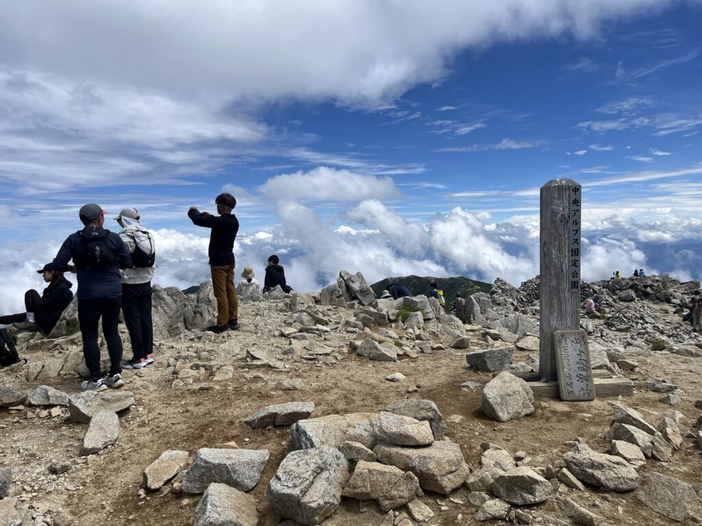 木曽駒ヶ岳山頂の標識と登山者