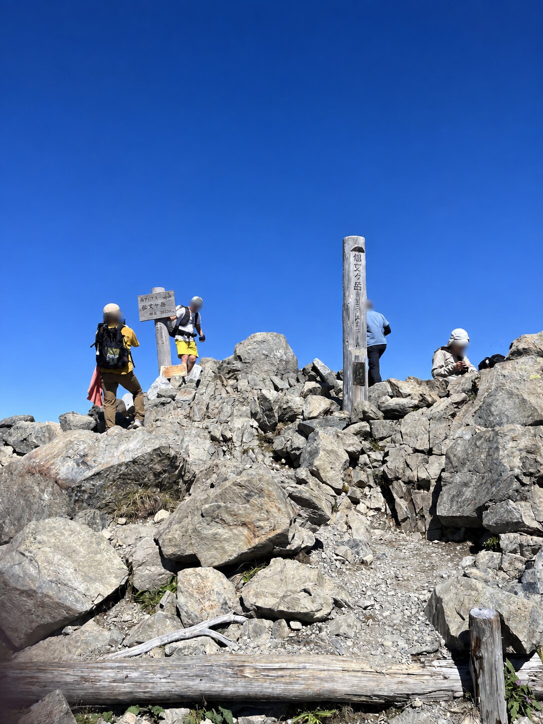 岩場に立つ標高3033メートルの仙丈ヶ岳山頂標識